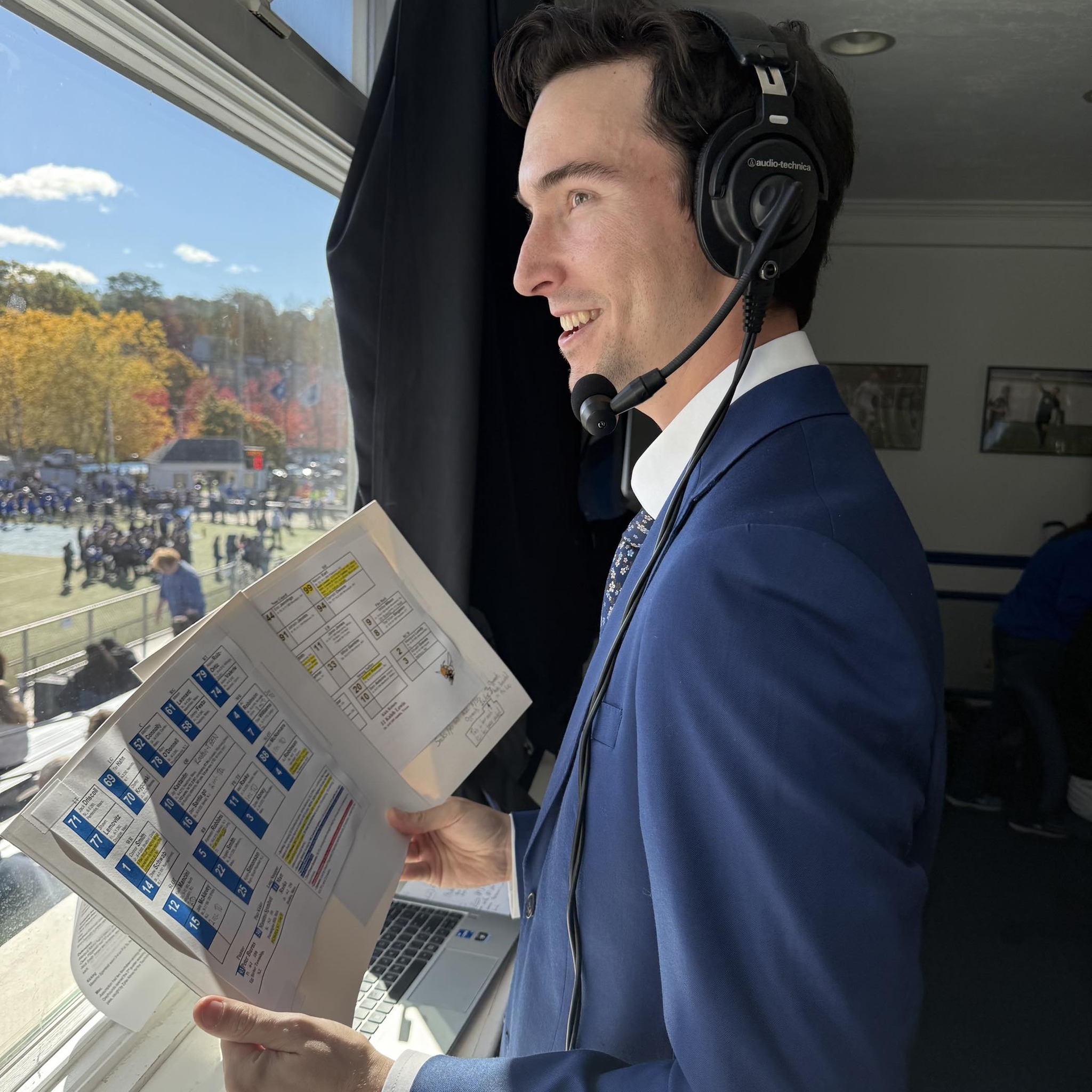 Berkley Stevens on the call in the broadcast booth, headset on, spotting chart in hand